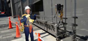 Trabajador preparando andamio en edificio urbano